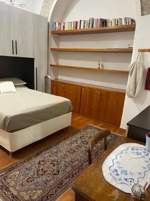 a bedroom with a bed and a table with a rug at Loft Accogliente - Piazza San Giovanni in Rome