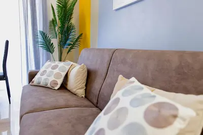 a brown couch with pillows and a plant on it at Elide - Nido d'amore in Ponte Milvio con Balcone in Rome