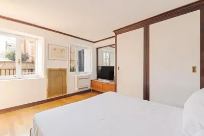a bedroom with a bed and a tv and windows at Piede Charming Apartment in Rome