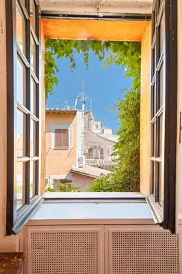 an open window with a view of a city at Piede Charming Apartment in Rome
