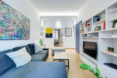 a living room with a blue couch and a tv at Incantevole appartamento in pieno centro a Roma in Rome
