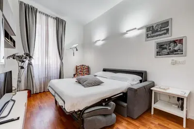 a small bedroom with a bed and a chair at MONTI44 Boutique Apartment in Rome