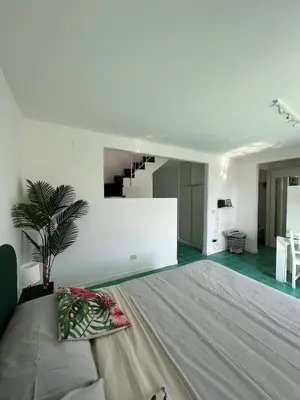 a bedroom with a large bed and a living room at Loft Panoramico San Giovanni in Rome