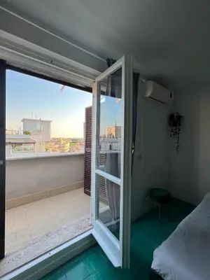 a bedroom with a view of a balcony at Loft Panoramico San Giovanni in Rome
