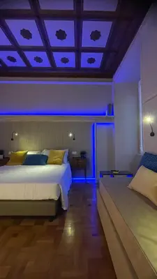 a bedroom with two beds and a blue lighting at Z-ArchSuites Urbs in Rome