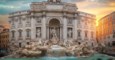 a large building with a fountain in front of it at Boho Suites - Rome Colosseum in Rome