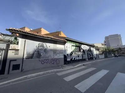 a building with graffiti on the side of a street at Lovely Apartment in Hip and Vibrant Pigneto in Rome