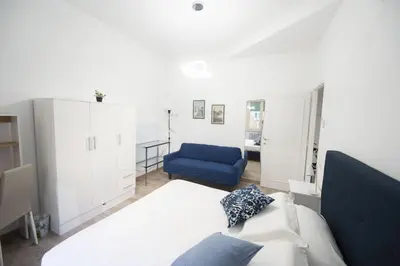 a bedroom with a bed and a blue couch at Lovely Apartment in Hip and Vibrant Pigneto in Rome