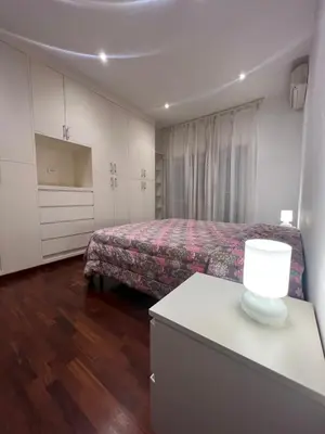a bedroom with a bed and a table with a lamp at Goiran@4 in Rome