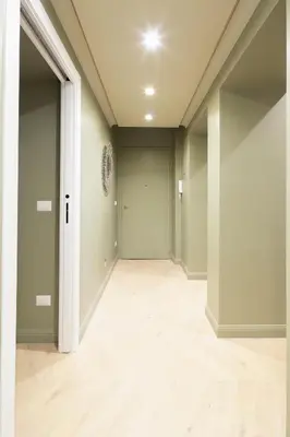 an empty hallway with green walls and wood floors at MAISON CAIO 7 in Rome