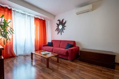 a living room with a red couch and a table at Rialto Apartment Vatican Museums in Rome