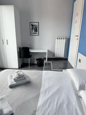 a bedroom with a bed with a desk and a chair at The Manzoni in Rome