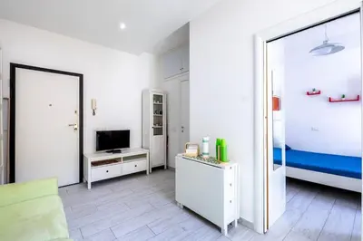 a white room with a bed and a mirror at Casa Sosò... La casa che fa per te! in Rome