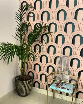a plant in front of a wall with a pink and black pattern at Good Time Apartment in Rome