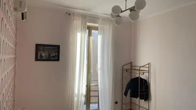 a white hallway with a mirror and a window at Good Time Apartment in Rome