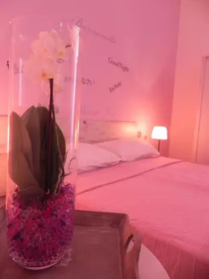 a vase with flowers on a table next to a bed at Vica Pota in Rome
