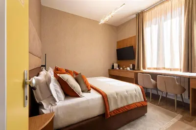 a bedroom with a bed and a desk with chairs at Royal Rooms Corso in Rome