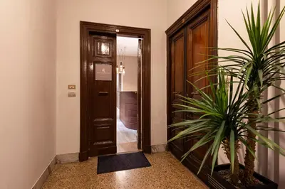 a hallway with a door and a potted plant at Royal Rooms Corso in Rome