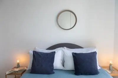 a bed with blue and white pillows and a mirror at Amazing Campo de' Fiori in Rome