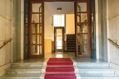 a hallway with two doors and a red rug at Romatic in Rome