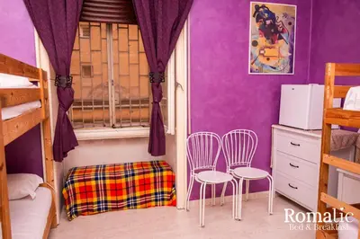 a bedroom with purple walls and two chairs and a window at Romatic in Rome