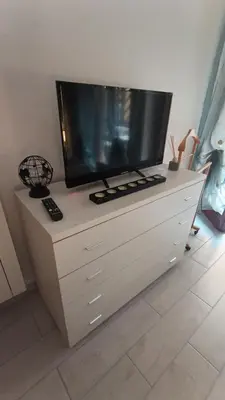 a television on top of a dresser in a room at Casilina One in Rome