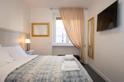 a bedroom with a bed with a tv and a window at St. Peter Boutique Apt in Rome
