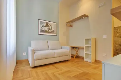a living room with a white couch and a table at Dea Rome Suites in Rome