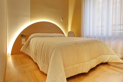 a bedroom with a large bed with an arch in it at Dea Rome Suites in Rome
