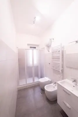 a white bathroom with a toilet and a sink at Emily a Roma home in Rome