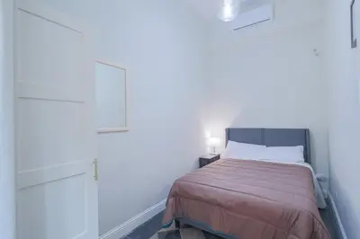 a small bedroom with a bed and white walls at Casa Prefetti 46 B in Rome
