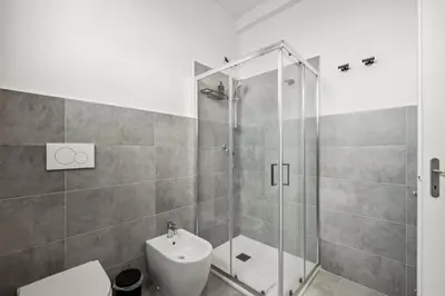 a bathroom with a shower and a toilet and a sink at Limehome Rome via dei Reti in Rome
