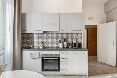 a kitchen with white cabinets and a stove at Limehome Rome via dei Reti in Rome