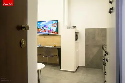 a room with a table and a television on a wall at GuestHost - Largo Leopardi Modern Apartment in Rome