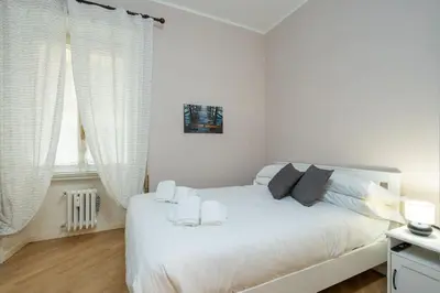 a white bedroom with a white bed with white curtains at Vaticano vicino metro A-Comfort ed eleganza in Rome
