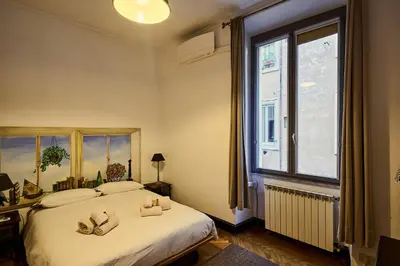 a bedroom with two beds and a large window at Vittorio Apartment Rome in Rome