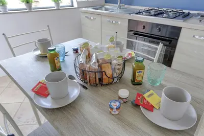 a kitchen table with two cups and a basket of food at LOFT CAPOCCI 37 - Home and More in Rome