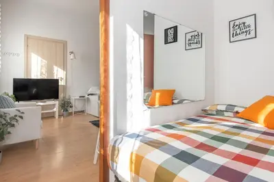 a bedroom with a bed and a living room at central little basic apartment in Rome