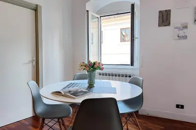 a white table with chairs and a vase of flowers on it at Cozy Navona Flat in Rome