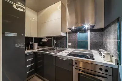 a kitchen with white cabinets and a stove top oven at GuestHost - Nel cuore di Trastevere Cozy Apartment in Rome