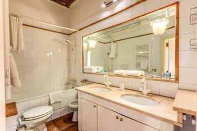 a bathroom with two sinks and a toilet and a mirror at Flat with Lovely Views near Piazza Navona in Rome