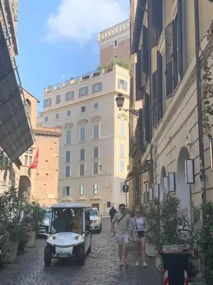 a man driving a golf cart down a street at Casa Claudia ~ rione Monti-Colosseo in Rome