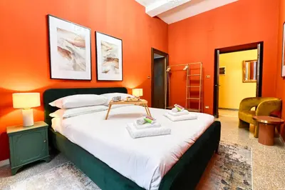 a bedroom with a large bed with orange walls at Elegant oasis among the Vatican and Via del Corso in Rome