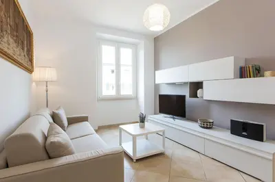 a white living room with a couch and a tv at Taurasia By Rental in Rome in Rome