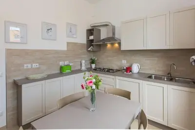 a kitchen with a table with a vase of flowers on it at Taurasia By Rental in Rome in Rome