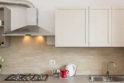 a kitchen counter with white cabinets and a sink at Taurasia By Rental in Rome in Rome