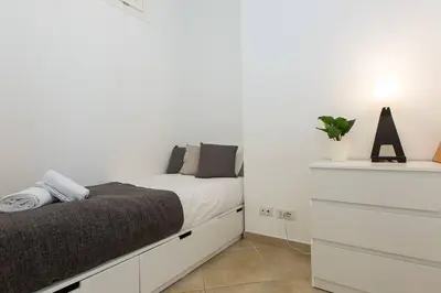 a white bedroom with a bed and a dresser at Taurasia By Rental in Rome in Rome
