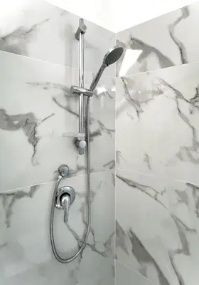 a shower in a bathroom with marble walls at Avocado House - Cozy Apartment in the Heart of Rome in Rome