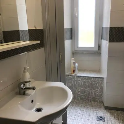 a white sink in a bathroom with a window at Colibrì Apartment in Rome