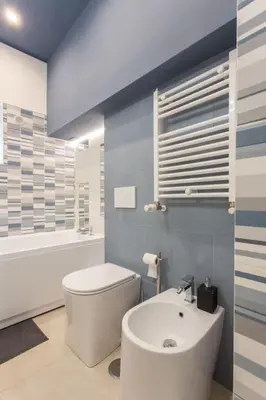 a bathroom with a white toilet and a sink at Frangipane 31 Monti Terrace in Rome